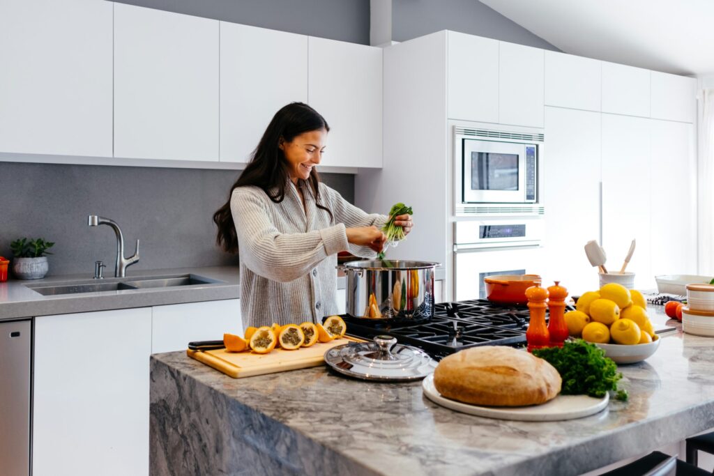 a woman smiling while cooking in the kitchen