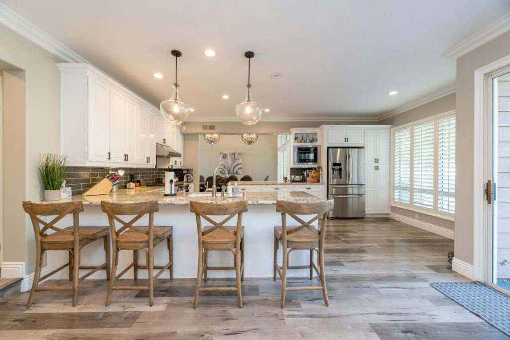 a view of a kitchen and four wooden chairs lined up near the breakfast nook
